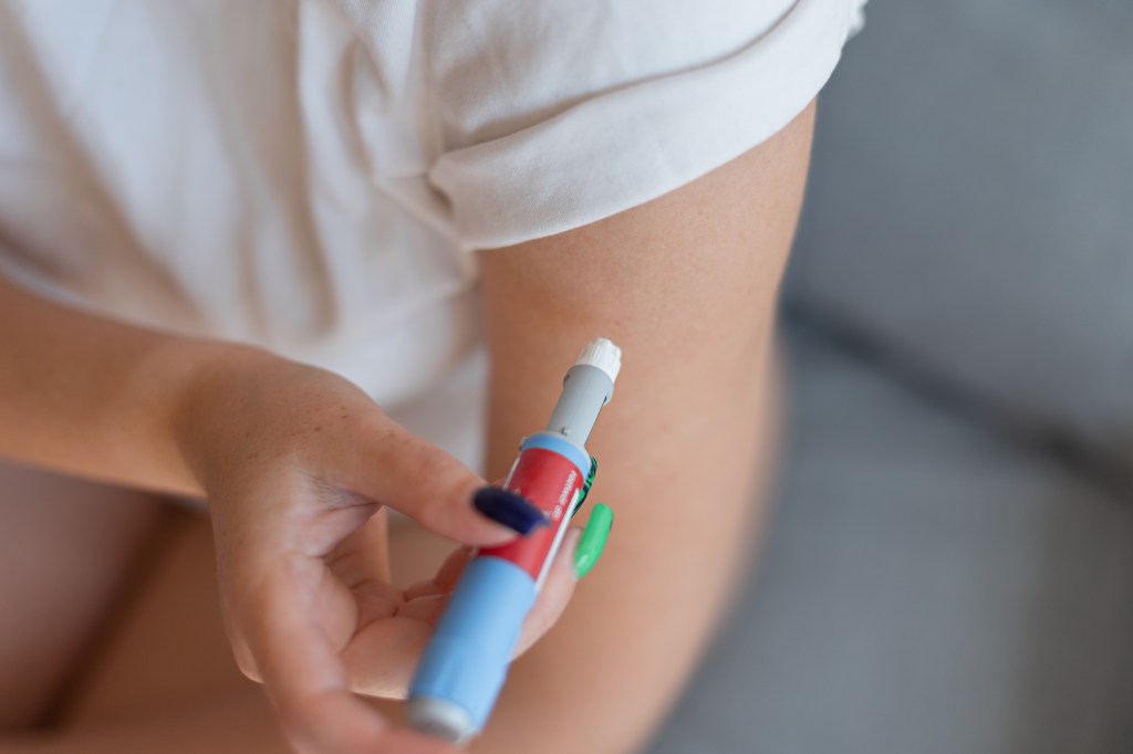 Girl giving a dose of antidiabetic medication via injection pen at home for weight loss